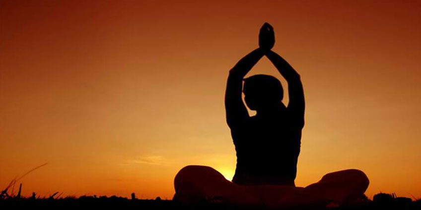 a person doing yoga at sunset